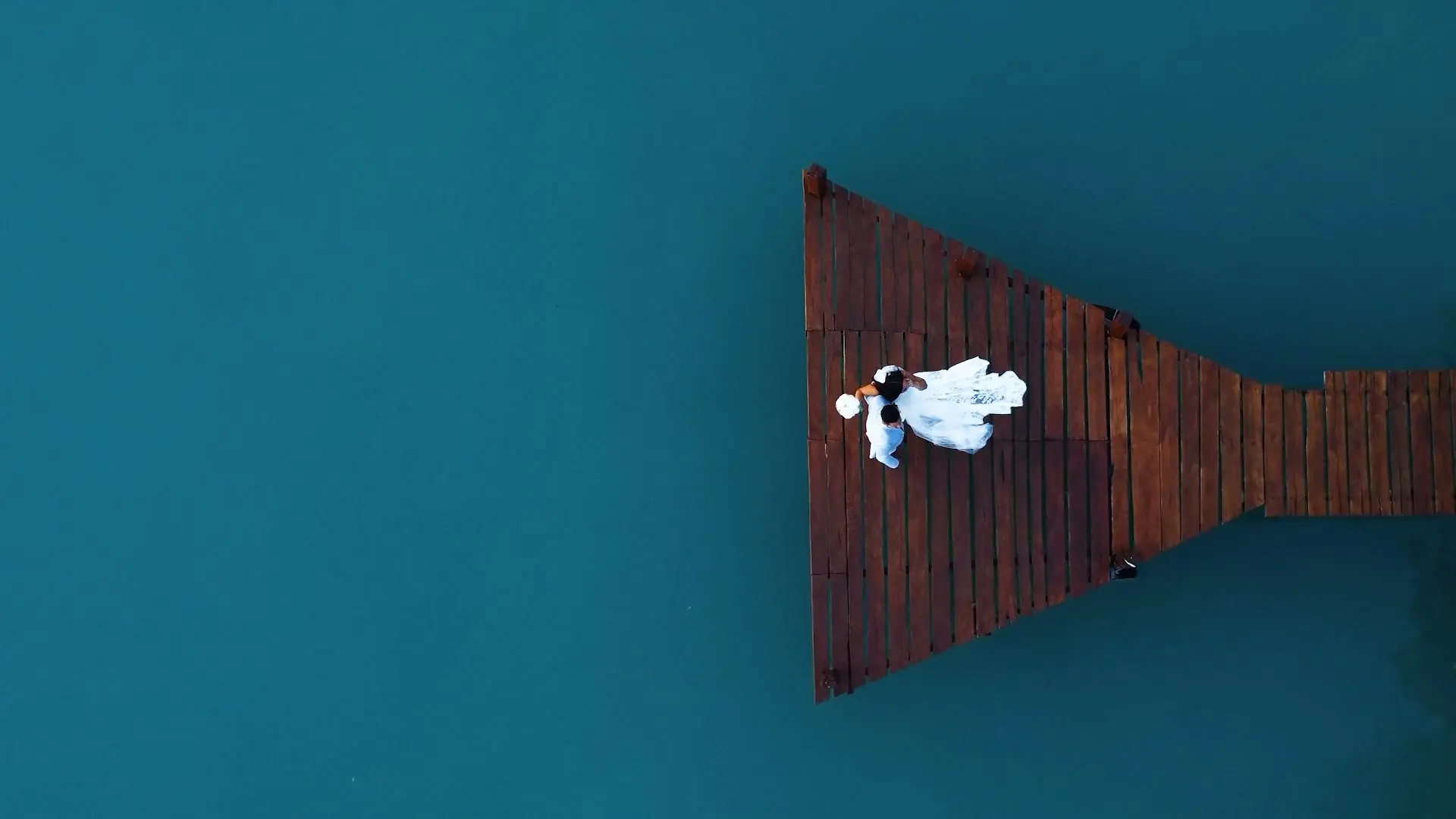 Novia sobre un muelle de madera en la laguna de Bacalar, vista aérea
